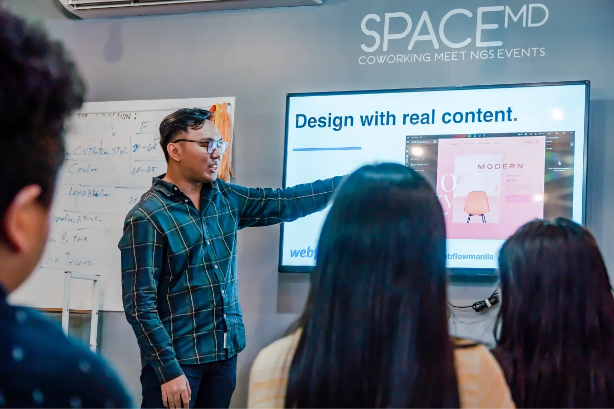 JP Dionisio presenting a slide that says Design with real content at a Webflow Manila meetup